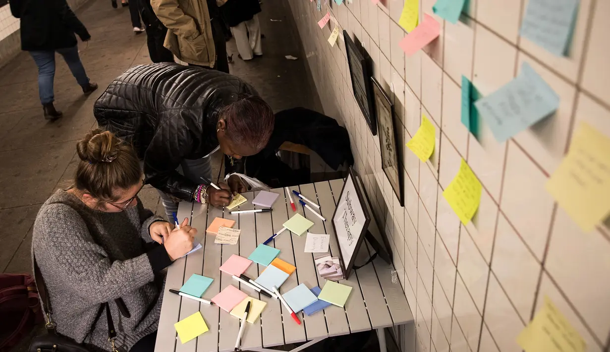 Sejumlah warga menulis di post-it sebagai bagian 'subway therapy' di dinding stasiun Union Square, New York, Kamis (10/11). Subway therapy digunakan kaum komuter yang kesal dan kecewa dengan terpilihnya Donald Trump sebagai Presiden AS (DREW ANGERER/AFP)