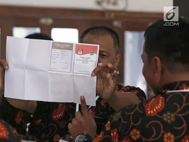 Petugas menunjukkan surat suara saat penghitungan suara Pilkada Jawa Barat 2018 di TPS 06 Nagrak, Gunung Putri, Bogor, Rabu (27/6). TPS tersebut menjadi tempat keluarga besar SBY menunaikan haknya pada Pilgub Jabar 2018. (Liputan6.com/Herman Zakharia)