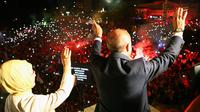 Presiden Turki Recep Tayyip Erdogan dan istri, Emine menyapa pendukung Partai Keadilan dan Pembangunan (AKP) di Ankara, Turki, Senin (25/6). Erdogan menang pemilu presiden Turki dengan meraih 58,76 persen suara. (Presidency Press Service via AP, Pool)