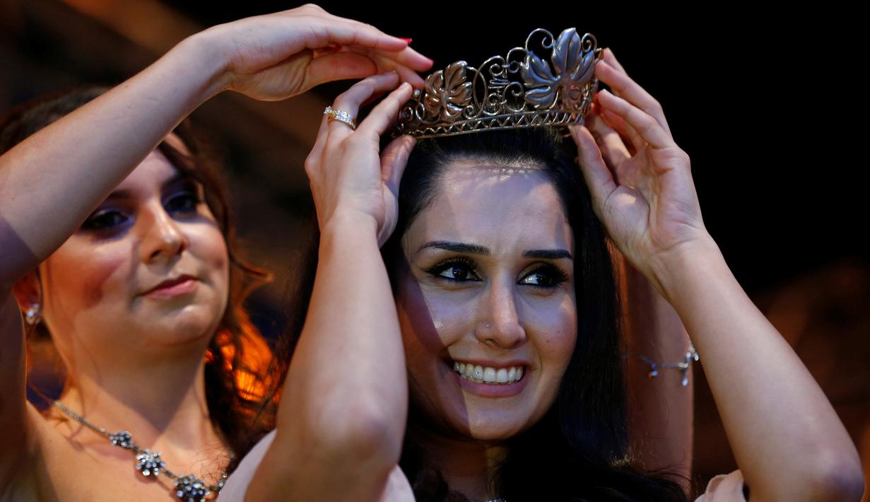 Pengungsi wanita asal Suriah, Ninorta Behno saat menerima mahkota Wine Queen/Ratu Anggur di Trier, Jerman (3/8). Ninorta Behno merupakan seorang pengungsi Suriah yang tinggal di Trier. (REUTERS/Ralph Orlowski)
