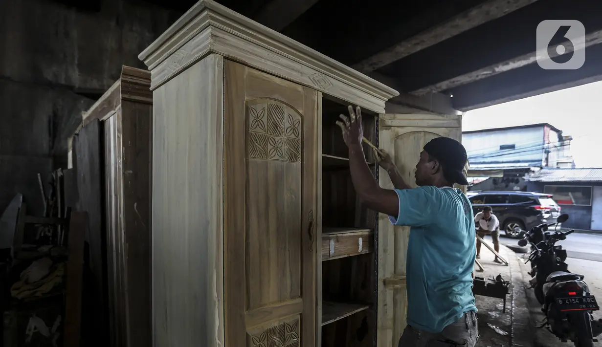 Pekerja menyelesaikan pembuatan furniture (perlengkapan rumah) di kolong Flyover Kranji, Bekasi, Jawa Barat, Sabtu (7/11/2020). Sebelum pandemi COVID-19, pedagang bisa menjual lima sampai tujuh unit furniture per hari, tapi kini hanya satu bahkan tidak sama sekali. (Liputan6.com/Johan Tallo)