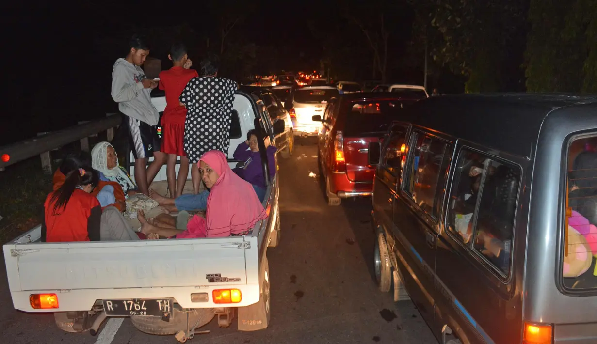 Warga menaiki mobil bak mengungsi ke tempat yang lebih tinggi menyusul terjadinya gempa di Cilacap, Jawa Tengah (16/12). Gempa berkekuatan 6,9 SR yang mengguncang Pulau Jawa membuat warga berada di apartemen panik. (AP Photo / Wagino)