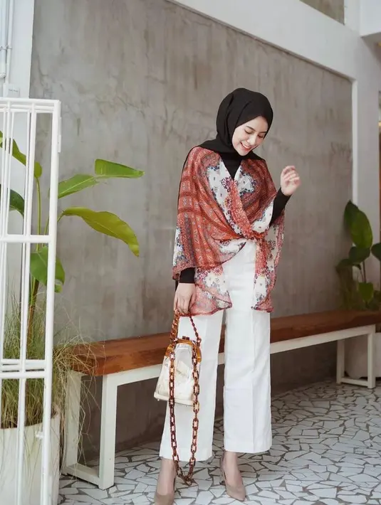 Outer model kimono dengan manset sebagai inner dan kulot putih jadi outfit kondangan yang simple namun tetap stylish. (Instagram/emyaghnia).
