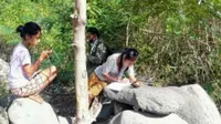 Diatas batu merupakan titik sinyal. Beberapa siswa yang sedang mengerjakan tugas sekolah melalui jaringan internet di tengah hutan. (Foto Istimewah)