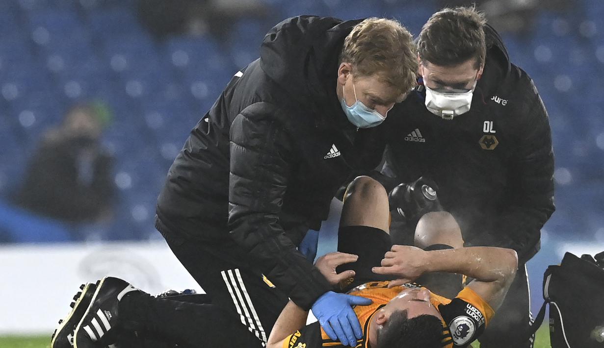 Gelandang Wolverhampton Wanderers, Daniel Podence mendapat perawatan medis akibat cedera dalam laga lanjutan Liga Inggris 2020/21 pekan ke-20 melawan Chelsea di Stamford Bridge, Rabu (27/1/2021). Wolverhampton bermain imbang 0-0 dengan Chelsea. (Pool via AP/Neil Hall)