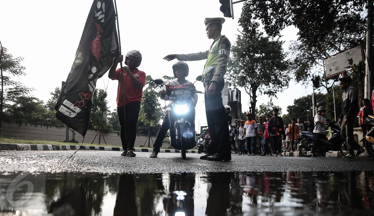 Petugas kepolisian merazia  suporter yang membawa bendera dengan  tongkat disekitar kawasan Gelora Bung Karno, Jakarta, Minggu (8/5/2016). Razia tersebut dilakukan untuk mengatisipasi keributan antar supporter. (Liputan6.com/Faizal Fanani)