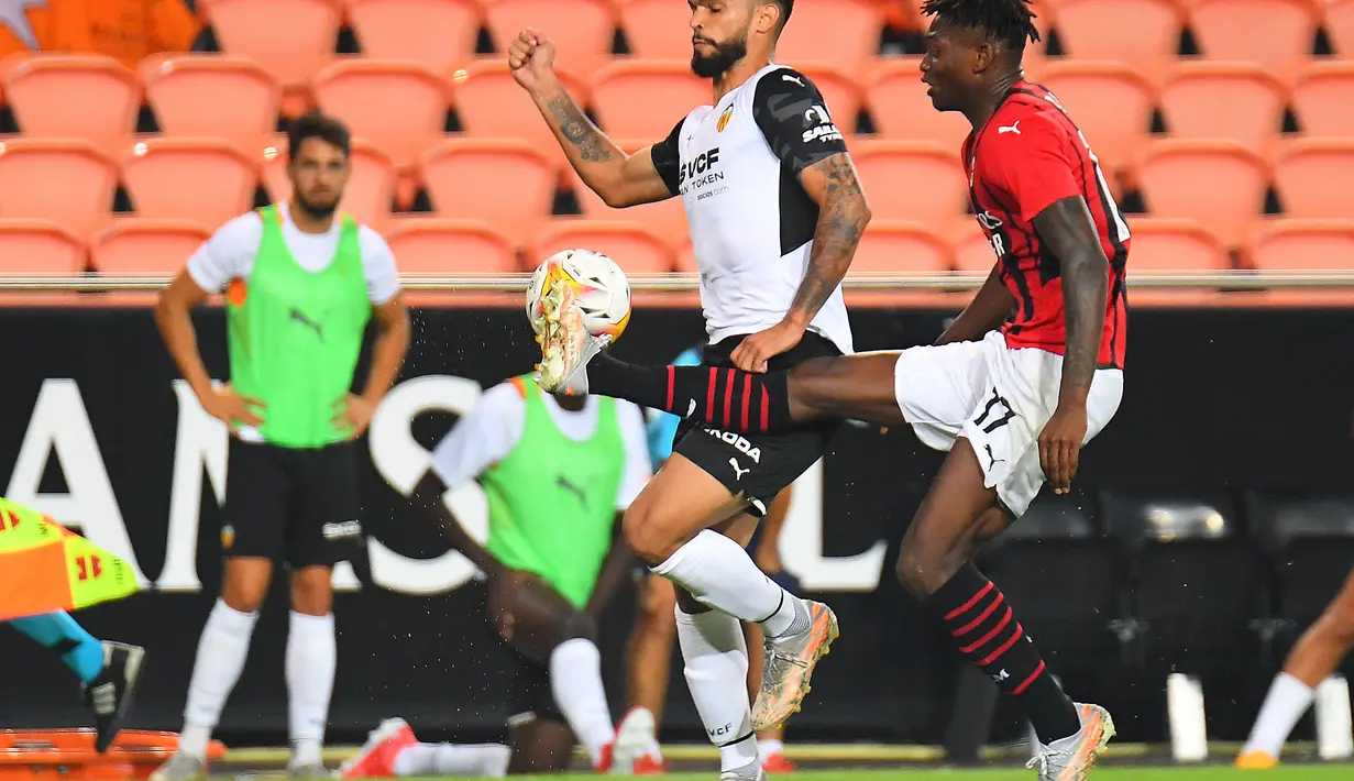 Penyerang AC Milan, Rafael Leao mengontrol bola dari kawalan bek Valencia, Omar Alderete selama pertandingan persahabatan di Stadion Mestalla di Valencia (4/8/2021). Bermain imbang 0-0 di waktu normal, AC Milan kalah atas Valencia lewat adu penalti 5-3. (AFP/Jose Jordan)