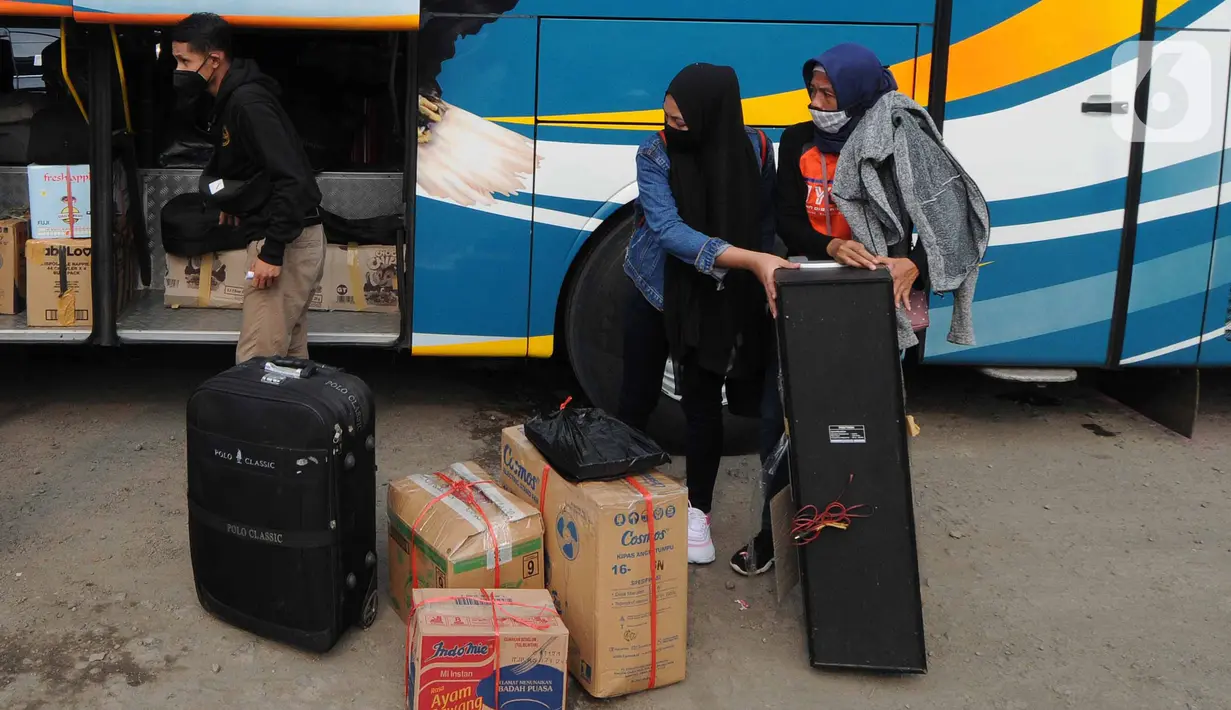 Pemudik memasukkan bawaan ke dalam bagasi bus di terminal bayangan di Pasar Jumat, Jakarta, Rabu (5/5/2021). Jelang pemberlakuan larangan mudik 2021 pada esok hari, sejumlah terminal bayangan di wilayah Jabodetabek dipadati para pemudik tujuan Pulau Jawa dan Sumatera. (merdeka.com/Arie Basuki)