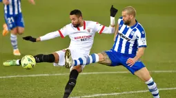 Penyerang Sevilla, Youssef En-Nesyri, berebut bola dengan bek Alaves, Victor Laguardia Cisneros, pada laga lanjutan Liga Spanyol di Stadion Mendizorrotza, Rabu (20/1/2021) dini hari WIB. Sevilla menang 2-1 atas Alaves. (AFP/Ander Gillenea)