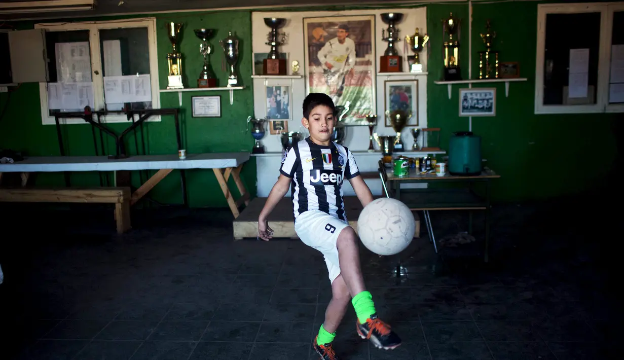 Seorang bocah mengenakan baju Juventus dengan nama Arturo Vidal di pinggiran kota Santiago. (Pablo Sanhueza)