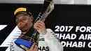 Valtteri Bottas mengangkat trofi juara seetalah finis pertama pada balapan F1 Abu Dhabi di Yas Marina circuit , (26/11/2017). (AFP/Giuseppe Cacace)