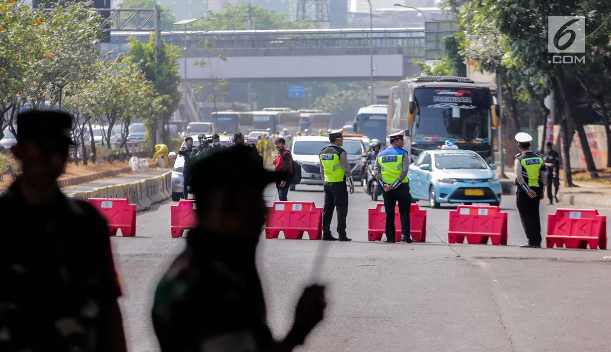 Petugas kepolisian mengatur lalu lintas di sekitar Gedung DPR/MPR RI, Jakarta, Selasa (1/10/2019). Pengamanan ekstra tersebut dilakukan jelang pelantikan anggota DPR RI periode 2019-2024. (Liputan6.com/Faizal Fanani)