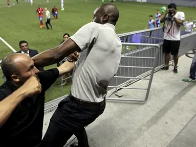 Pelatih tim sepakbola Costa Rica, Paulo Wanchope (kanan) berkelahi dengan petugas keamanan saat pertandingan melawan Panama pada kualifikasi Olimpiade di Maracana Stadium, Panama, Selasa (11/8/2015). (Reuters/Roberto Cisneros-La Prensa)