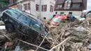 Sebuah mobil tertutup puing-puing menyusul bencana banjir dahsyat di Kota Braunsbach, Senin (30/5). Banjir melanda wilayah barat Jerman setelah hujan deras terjadi sepanjang Ahad (29/5) yang menewaskan empat orang. (Marijan Murat/dpa/AFP)
