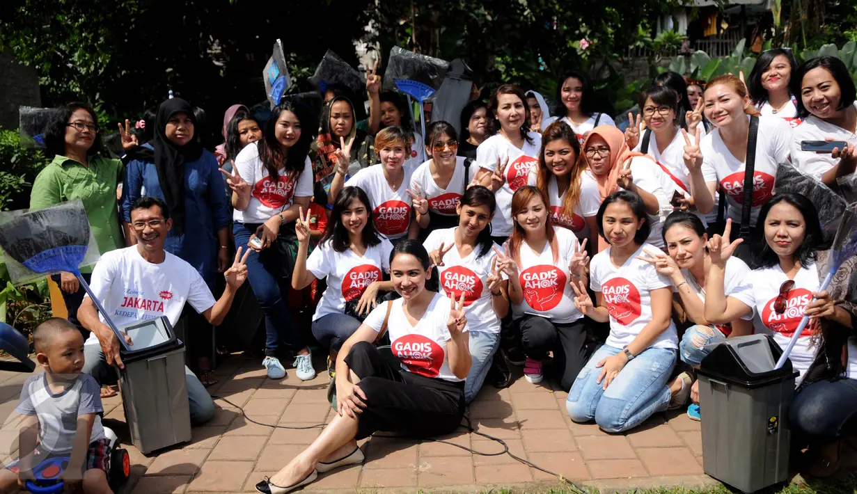 Relawan dari Gerakan Aksi Srikandi Coblos Ahok (Gadis Ahok) foto bersama dengan warga saat mendatangi kawasan Cipete, Jakarta Selatan, Senin (26/12). Mereka juga ikut membersihkan lingkungan sekitar di kawasan tersebut. (Liputan6.com/Gempur M Surya)