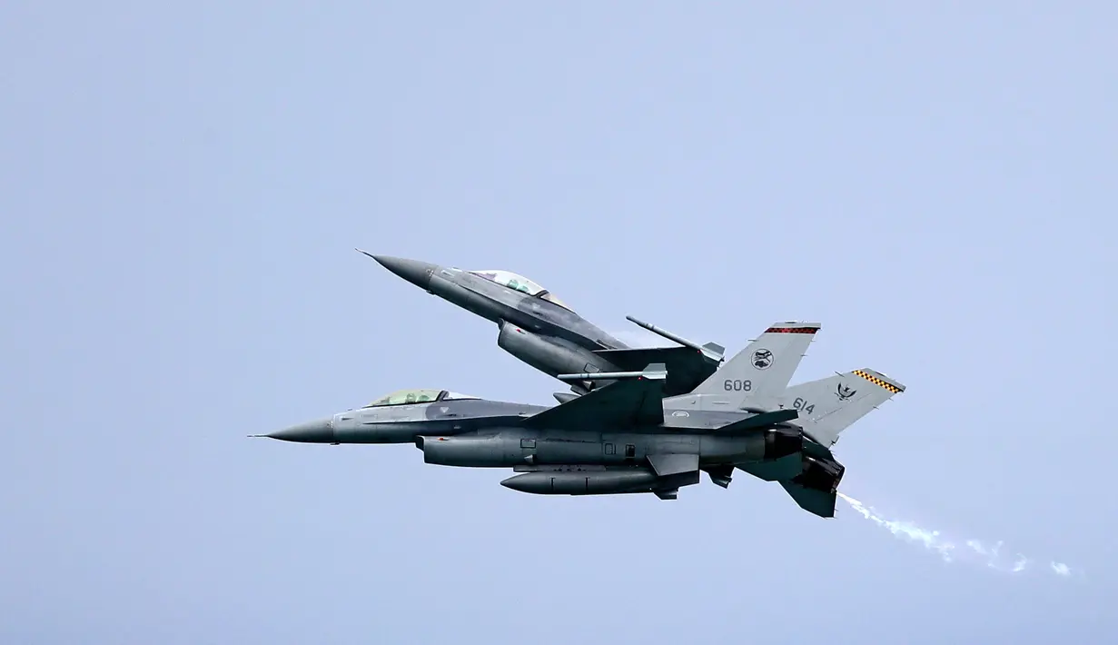 Aksi dua jet tempur F-16 Angkatan Udara Singapura melakukan manuver di udara jelang Singapore Airshow 2018, Jumat (2/2) . Singapore Airshow 2018 akan dihadiri delegasi pemerintah dan militer tingkat tinggi dari seluruh dunia. (AP Photo/Wong Maye-E)