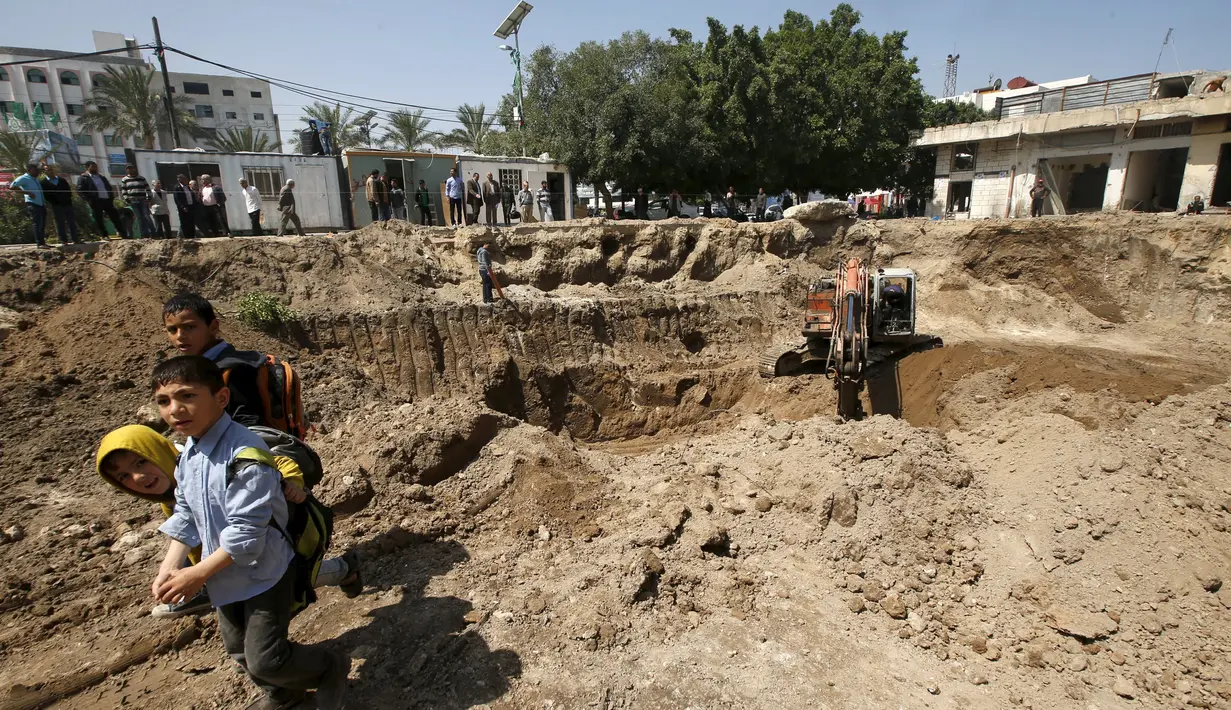 Sejumlah anak melihat excavator yang sedang melakukan penggalian, yang dipercaya oleh arkeolog merupakan bagian dari gereja Bizantium yang berusia sekitar 1.500 tahun lalu di kota Gaza, Senin (4/4/2016). (REUTERS/Mohammed Salem)