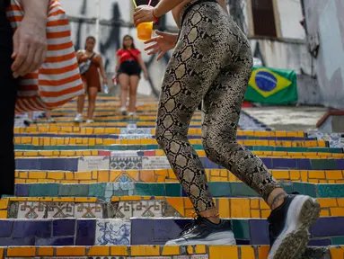 Orang-orang berlalu-lalang di anak tangga yang terkenal dengan nama Selaron Steps atau Escadaria Selarón di Rio de Janeiro, Brasil pada 9 Desember 2019. Escadaria Selaron merupakan 250 anak tangga sepanjang 125 meter dengan dua ribuan ubin berwarna-warni. (Photo by David GANNON / AFP)