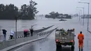 Sebuah kendaraan darurat memblokir akses menuju Jembatan Windsor yang banjir di pinggiran Sydney, Australia, Senin (4/7/2022). Lebih dari 30.000 penduduk Sydney dan sekitarnya telah diberitahu untuk mengungsi atau bersiap untuk meninggalkan rumah mereka pada hari Senin di tengah kondisi cuaca yang buruk. (AP Photo/Mark Baker)