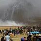Pasukan Israel menembakkan gas air mata ke arah demonstran Palestina selama bentrokan di perbatasan jalur Gaza (11/5). Sejak aksi digelar kembali pada 30 Maret 2018, sekitar 50 warga Palestina telah tewas oleh tembakan Israel. (AFP Photo/Mohammed Abed)