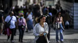 Orang-orang berjalan di pusat kota Lisbon, Portugal, Senin (13/9/2021). Portugal hari ini mengakhiri aturan wajib penggunaan masker di jalan-jalan. (PATRICIA DE MELO MOREIRA / AFP)