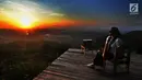Seorang wisatawan menunggu matahari terbenam di Puncak Watu Goyang usai berkeliling dengan jip di Desa Wisata Kaki Langit Mangunan, Bantul, Yogyakarta (4/5). (Merdeka.com/Arie Basuki)