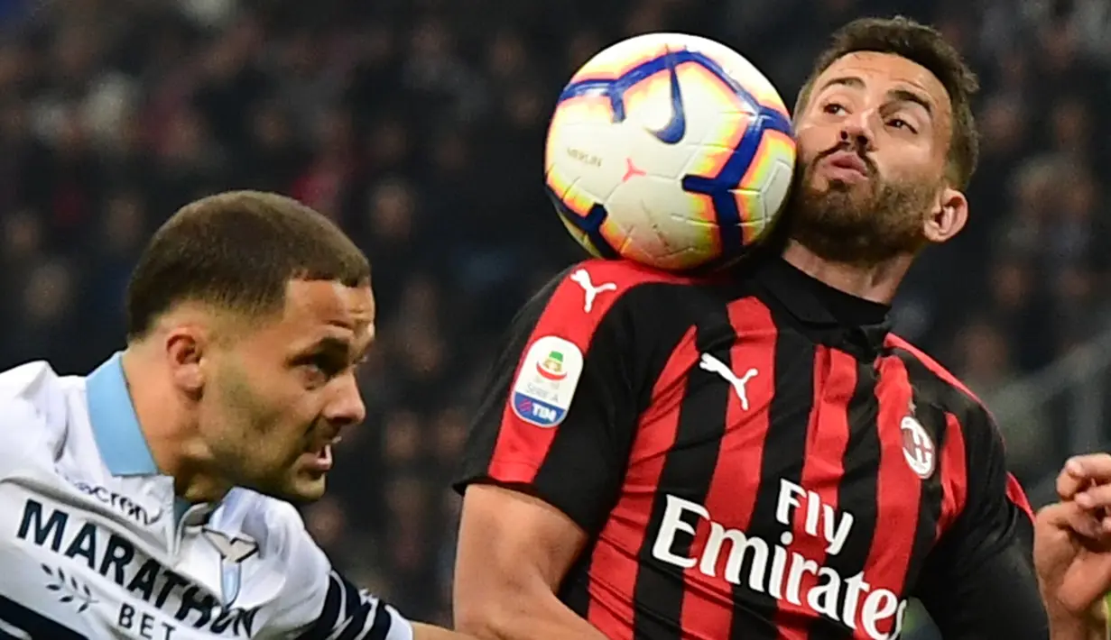 Bek AC Milan, Mateo Musacchio mengontrol bola dari kawalan bek Lazio, Riza Durmisi selama pertandingan lanjutan Liga Serie A Italia di stadion San Siro (13/4). Milan menang tipis atas Lazio 1-0. (AFP Photo/Miguel Medina)