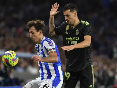 Gelandang Real Madrid Dani Ceballos berebut bola dnegan penyerang Real Sociedad  Mikel Oyarzabal pada pekan ke-33 Liga Spanyol 2022/2023 di Reale Arena, Rabu (3/5/2023) WIB.  (AP Photo/Alvaro Barrientos)