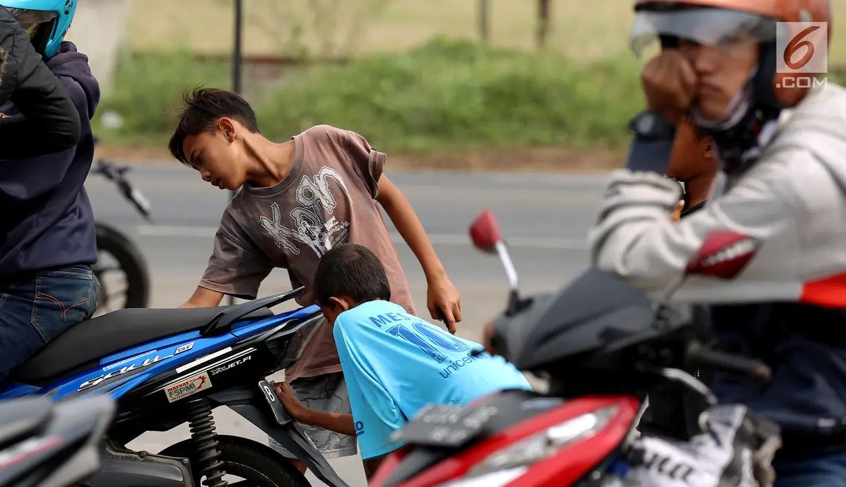 Anak - anak di SPBU Tanjung Pantura - Brebes membersihakan motor pemudik dari Jakarta menuju kampung halamannya, Kamis (22/6). Memanfaatkan moment mudik ini anak - anak pantura mengais rejeki untuk lebaran 1438 H. (Liputan6.com/Johan Tallo)