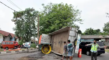 Jumat (15/8/14), sebuah truk yang membawa mesin untuk kapal, terbalik di dekat stasiun Cakung, Jakarta. (Liputan6.com/Panji Diksana)
