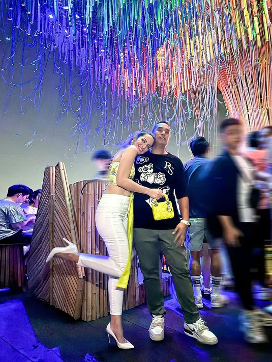 Ia mengenakan cropped strapless top model bohemian dengan skinny pants putih dan heels putih [@ramadhaniabakrie]