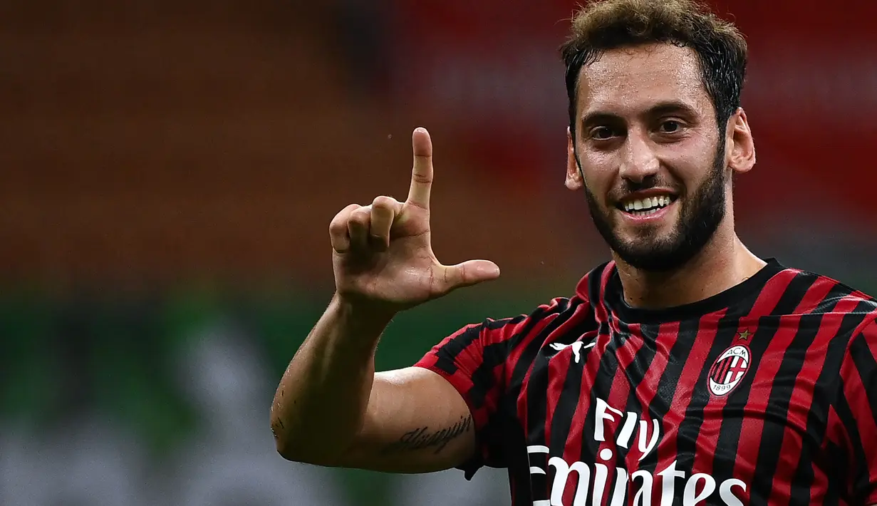 Gelandang AC Milan Hakan Calhanoglu berselebrasi usai mencetak gol ke gawang Bologna pada pada pertandingan Liga Serie A Italia di Stadion San Siro di Milan pada 15 Juli 2020. (AFP/Marco Bertorello)