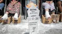 Sebuah nisan untuk Patmi (48), peserta aksi semen kaki yang meninggal, di depan Istana Merdeka, Jakarta, Rabu (22/3). Delapan aktivis menggelar aksi semen kaki yang sekaligus menghormati dan melanjutkan perjuangan Ibu Patmi. (Liputan6.com/Faizal Fanani)