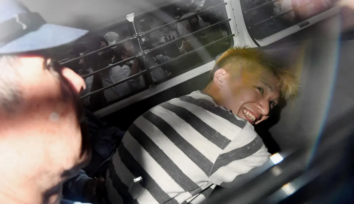 Pelaku pembantaian di sebuah panti penyandang cacat, Satoshi Uematsu terlihat tersenyum kepada awak media saat berada di dalam mobil di kantor polisi Tsukui, Sagamihara, Prefektur Kanagawa, Jepang, Rabu (27/7). (REUTERS/Issei Kato)