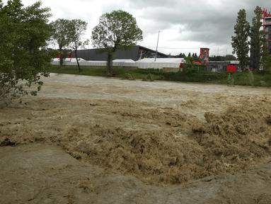 Aliran deras dari sungai Santerno yang letaknya bersebelahan dengan sirkuit Autodromo Enzo e Dino Ferrari, Rabu (17/5/2023). Sirkuit ini pun terkena banjir akibat luapan sungai yang letaknya tepat di sebelah sirkuit, meluap. (AP Photo/Luca Bruno)