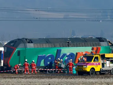 Petugas penyelamat berdiri di dekat dua kereta yang bertabrakan di Zurich, Swiss, (20/2/2015). Kereta bertabrakan di Swiss yang menyebabkan beberapa orang terluka dan rute komuter tergangu. (Reuters/ Arnd Wiegmann)