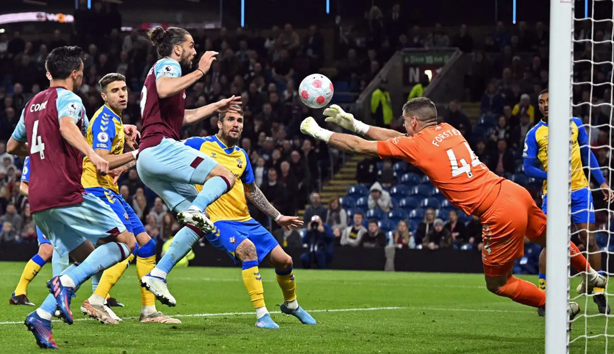 <p>Penjaga gawang Southampton Fraser Forster (kanan) mencoba meninju bola saat melawan Burnley pada pertandingan Liga Inggris di Turf Moor, Burnley, Inggris, 21 April 2022. Burnley menang 2-0. (Oli SCARFF/AFP)</p>