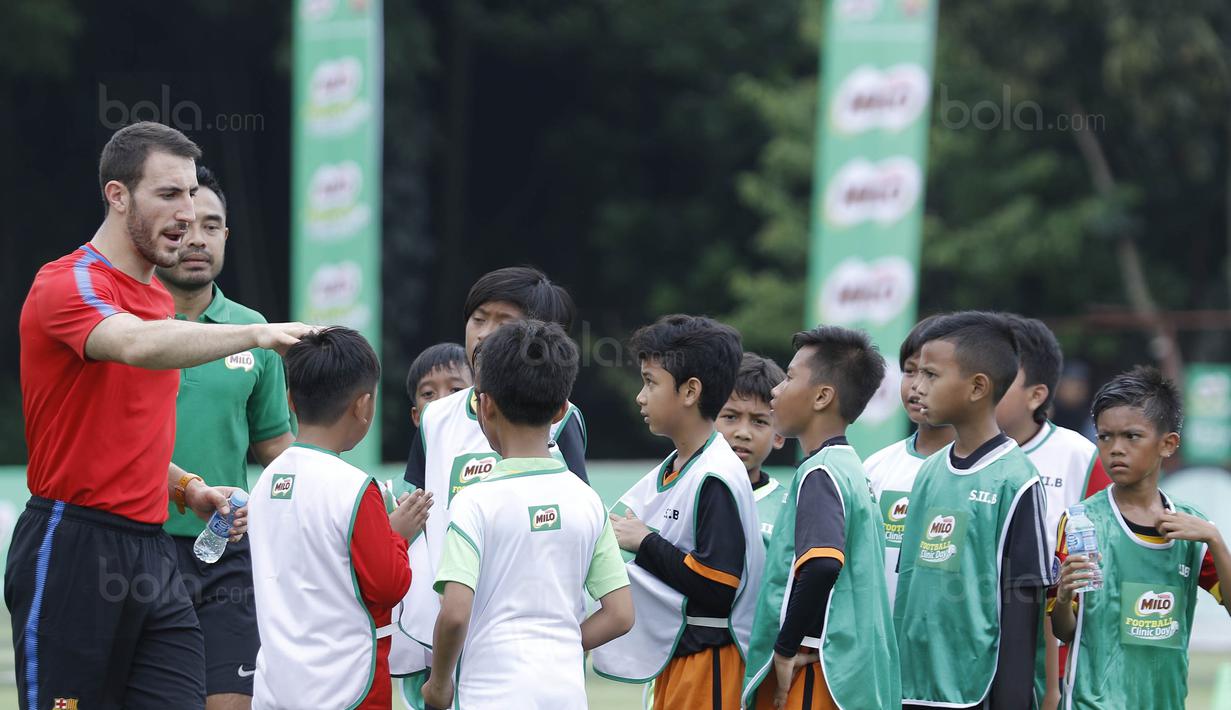 Pelatih FCBEscola, Aldric Miro, saat memberikan pelatihan MILO Football Clinic Day di Lapangan Simprug, Jakarta, Sabtu (16/12/2017). Sebanyak 500 anak mendapatkan pelatihan dasar teknik sepak bola dari pelatih berpengalaman. (Bola.com/M Iqbal Ichsan)