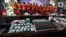 Barang bukti dan tersangka dihadirkan saat rilis kasus narkoba jaringan internasional di Gedung Bareskrim Mabes Polri, Jakarta, Kamis (11/8/2022). Dalam penyitaan terdapat barang bukti narkotika jenis pil xtc serta alat pembuatnya. (Liputan6.com/Faizal Fanani)