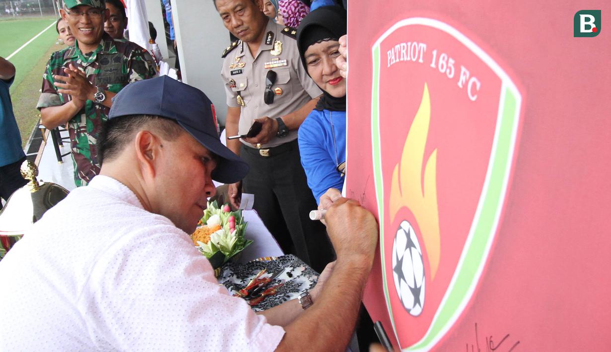 Pendiri Patriot 165 FC, Sudirman, membukukan tanda tangan pada logo klub  di Lapangan ABC Senayan, Jakarta, Rabu (28/3/2018). Acara ini dalam rangkaian peluncuran Patriot 165 FC. (Bola.com/Asprilla Dwi Adha)