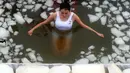 Seorang wanita berendam di dalam kolam es saat ikut ambil bagian dari tantangan  air es di Zhangjiajie, Tiongkok. Gambar ini diambil pada 25 Januari 2015. (AFP Photo)