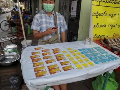 Seorang pedagang kaki lima memamerkan kartu SIM seluler di Yangon, Myanmar (4/2/2021).  Pemerintah militer baru Myanmar telah memblokir akses ke Facebook karena perlawanan terhadap kudeta yang melonjak di tengah seruan pembangkangan sipil. (AP Photo)