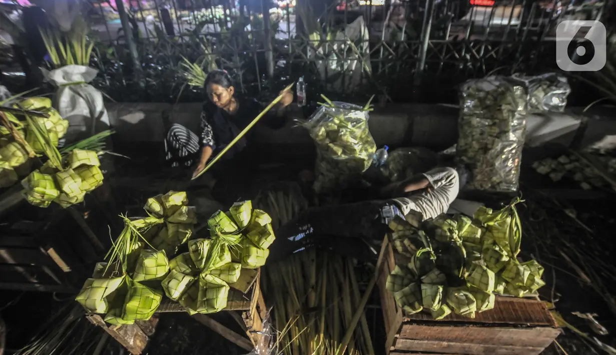 Aktivitas pedagang saat membuat bungkus atau tali ketupat di Pasar Klender, Jakarta Timur, Selasa (11/5/2021) malam. Tali ketupat di pasar ini dijual mulai dari Rp7.000 hingga Rp15.000 per ikat (10 buah), tergantung ukuran dan jenis daun kelapa. (merdeka.com/Iqbal S Nugroho)