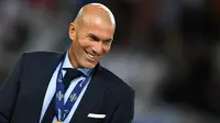 Zinedine Zidane tersenyum dengan medali usai memenangkan pertandingan melawan Manchester United di Arena Philip II di Skopje (8/8). Trofi Piala Super Eropa 2017 adalah trofi keenam yang dipersembahkan Zidane untuk Real Madrid. (AFP Photo/Dimitar Dikloff)