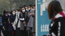 Wanita yang memakai masker wajah mengantre untuk mendapatkan tes usap tenggorokan COVID-19 rutin mereka di tempat pengujian virus corona di Beijing, Rabu (26/10/2022). Kota Shanghai di China mulai memberikan vaksin COVID-19 yang dapat dihirup pada hari Rabu di tempat yang tampaknya menjadi yang pertama di dunia. (AP/Andy Wong)