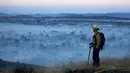 Petugas melihat kebakaran hutan di Cherry Valley, California (1/8/2020). Menurut Departemen Pemadam Kebakaran Wilayah dan Departemen Kehutanan dan Perlindungan Kebakaran California (Cal Fire), api telah meluas sejak Jumat (31/7) malam menjadi 4.125 hektar. (AP Photo/Ringo H.W. Chiu)