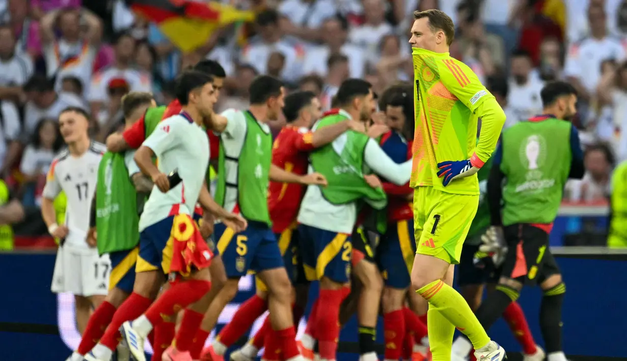 Ekspresi penjaga gawang Jerman, Manuel Neuer saat para pemain Spanyol merayakan kemenangan pertandingan perempat final Euro 2024 di Stuttgart Arena, Stuttgart, 5 Juli 2024 atau Sabtu 6 Juli 2024 dini hari WIB. (THOMAS KIENZLE/AFP)