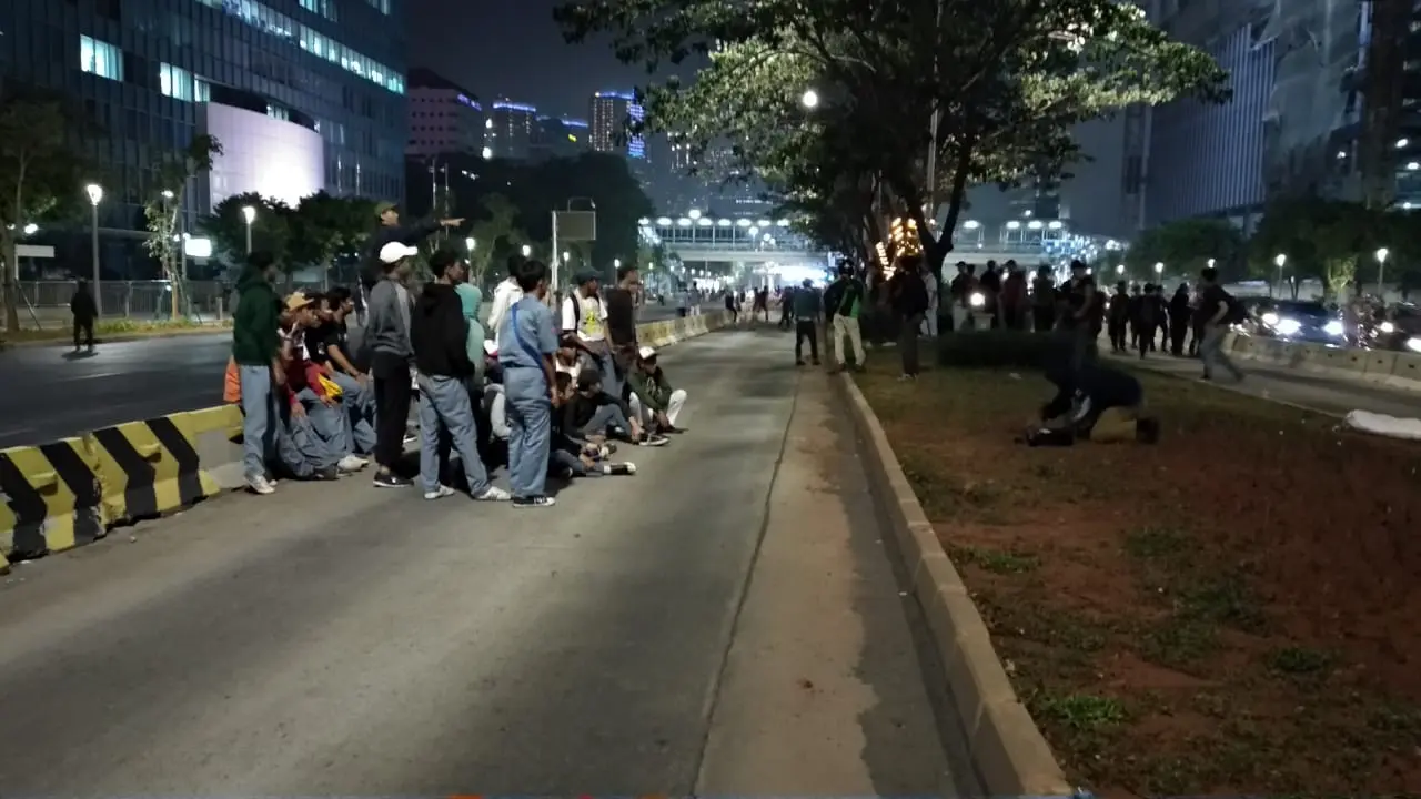 massa yang sebagian menggunakan seragam SMA menumpang truk ke arah Cawang. Mereka sempat berfoto di lintasan bus Transjakarta.
