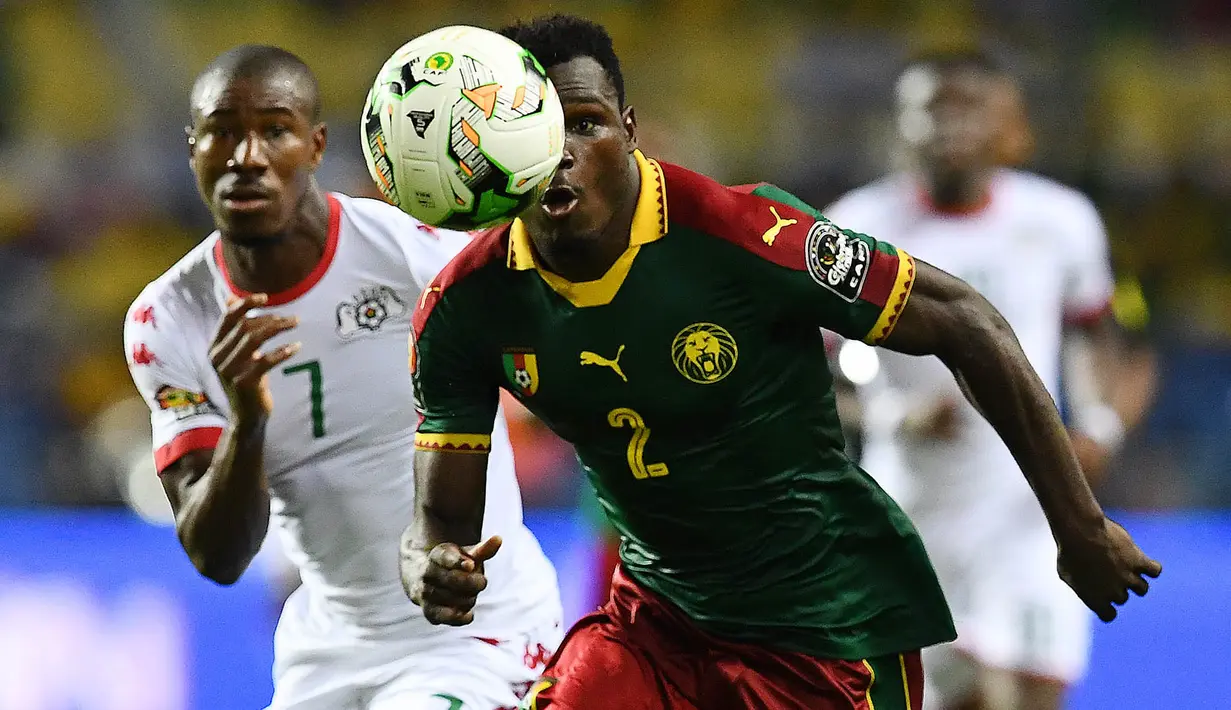 Bek Kamerun, Ernest Mabouka, berebut bola dengan gelandang Burkina Faso, Prejuce Nakoulma, pada laga Grup A Piala Afrika di Stade de l'Amitie Sino-Gabonaise, Gabon, Sabtu (14/1/2017). Kedua negara bermain imbang 1-1. (AFP/Gabriel Bouys)