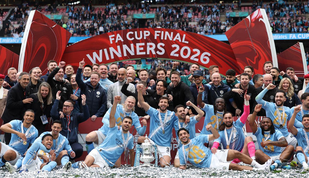 Para pemain dan staf Manchester City melakukan selebrasi usai meraih gelar Piala FA setelah mengalahkan Chelsea dengan skor 1-0 di partai final di Wembley Stadium hari Sabtu (16/05/2026) malam WIB. (AFP/Adrian Dennis)